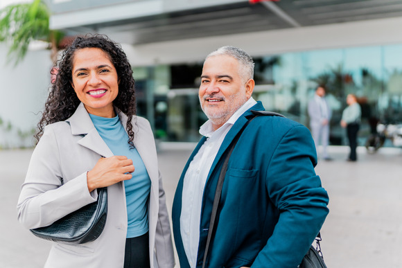 Woman and man pose outside their office.