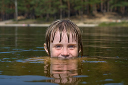Kid with head peaking out of lake water