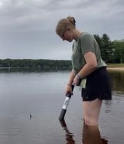 Environmental health technician testing lake water for blue-green algae