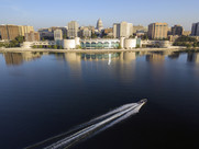 A boat moves across the water in front of Lake Monona in Madison, Wisconsin with the skyline in the background.