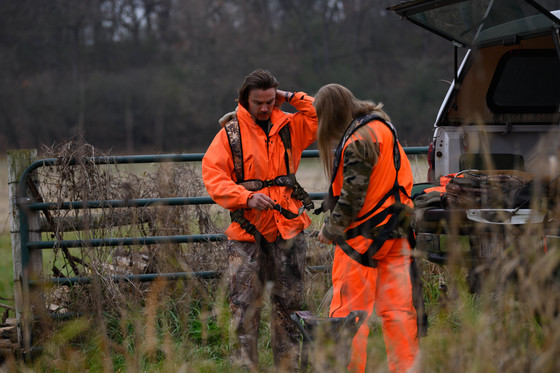 An image of two hunters getting their gear out the back of a truck. 