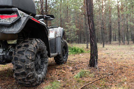 An image of an ATV parked in a forest. 