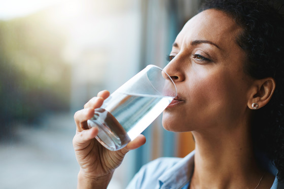 Woman drinking a glass of water at home