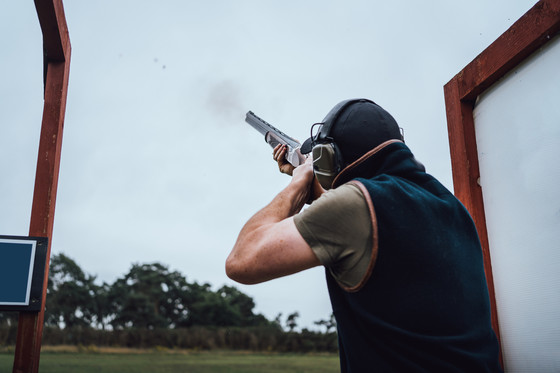 Man shooting shotguns at clay pigeon