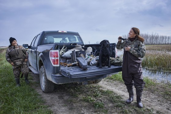 Two women standing by a pickup truck, getting ready to go duck hunting.