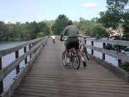 People biking on trestle bridge over river