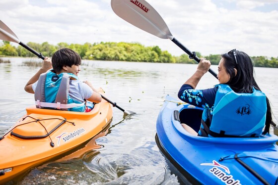 mother and son kayak alongside one another in a lake in janesville, WI