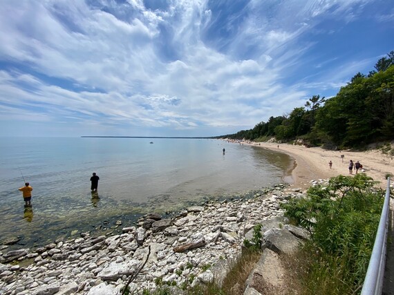 Lake Michigan beach and sand with people fishing and swimming