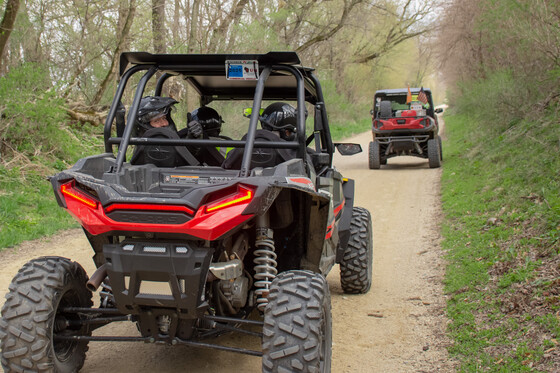 two red atvs riding along a gravel atv trail