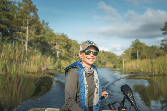 woman smiling on fishing boat wearing life jacket