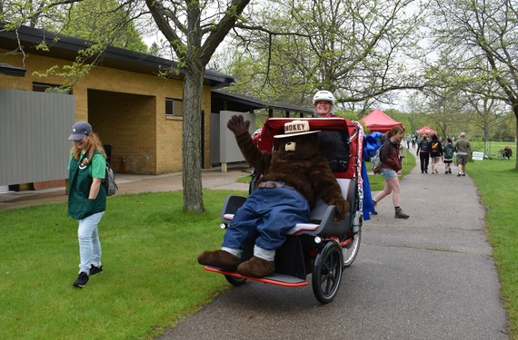 Smokey Bear riding in a trishaw bicycle at a state forest