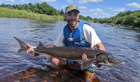 man posing with lake sturgeon