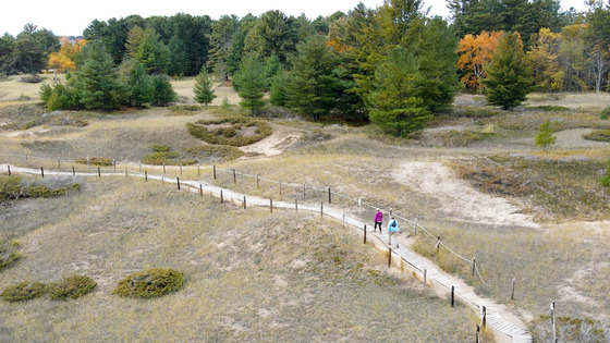 drone image of two women hiking along the boardwalk at kohler andrae state park