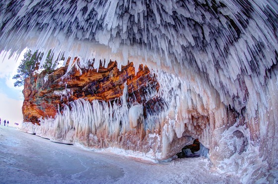 Ice formations form around the inside of a cave on the lakeshore. 