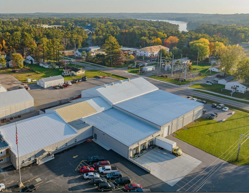 a drone picture of the DRM Industries Corporation's offices with cars, trucks and trees in the background