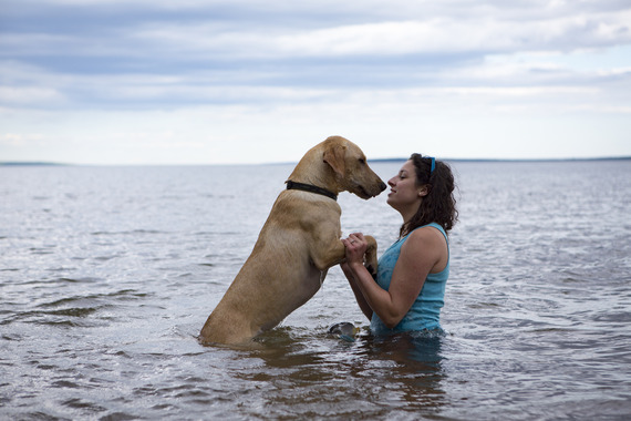 Woman standing in water with a dog