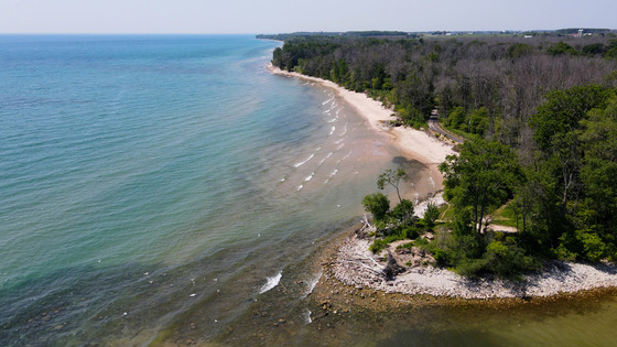 a drone photo of Harrington Beach State Park with a beach, lake and trees