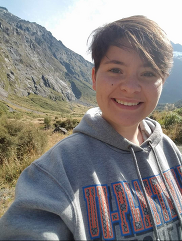 Haley Jahnel wearing a UW-Platteville sweatshirt taking a selfie in front of mountains