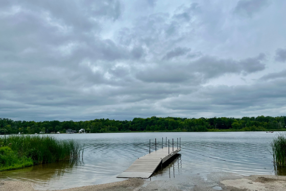 Long Lake and its boat dock are pictured beneath a sky filled with white clouds.