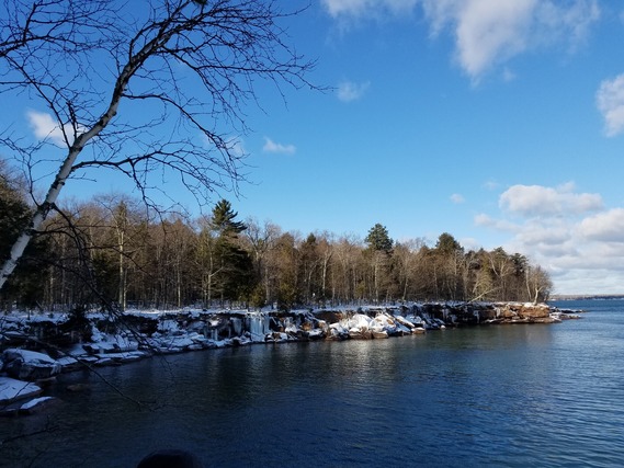 Unfrozen lake with snow on edges