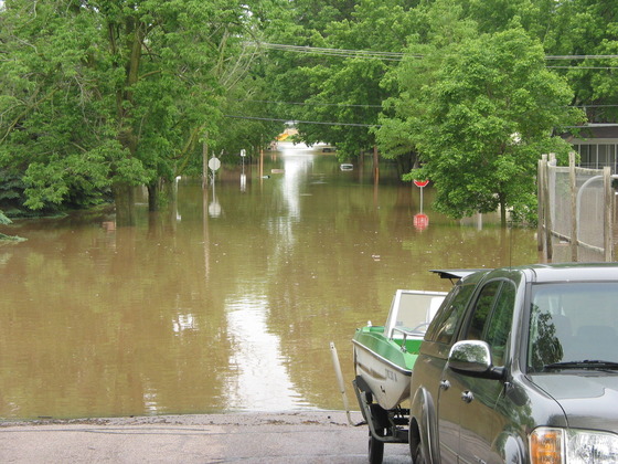 a pickup truck pulling a boat out of a flooded city street in Reedsburg