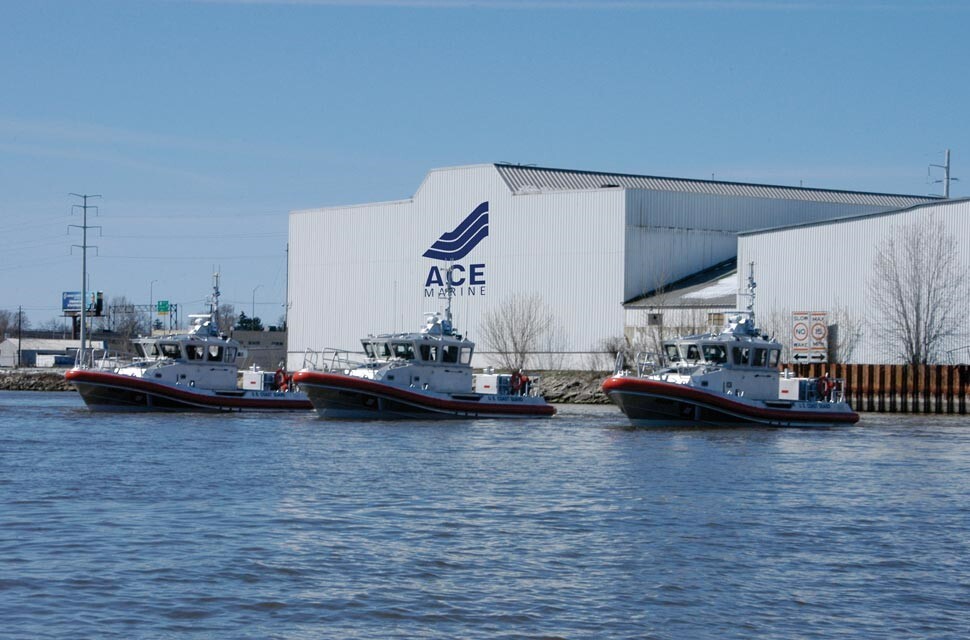 Three large boats sitting in the water. Behind them is a large white building that reads "ACE Maring."