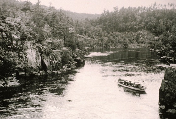 an historic image of Interstate Park with a boat and rocky areas overlooking the Dalles of the St. Croix River