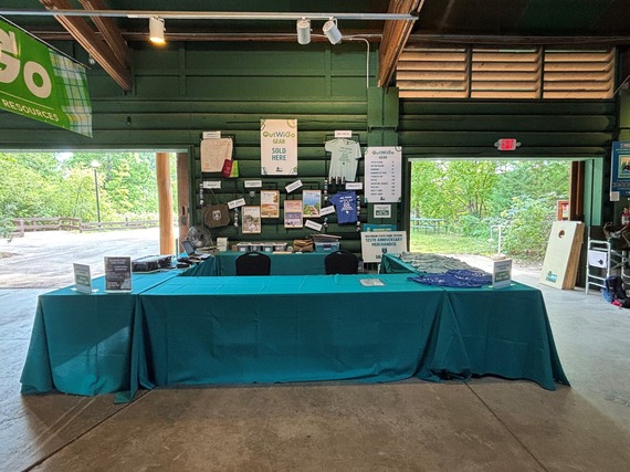 Tables with shirts and other items inside a green cabin