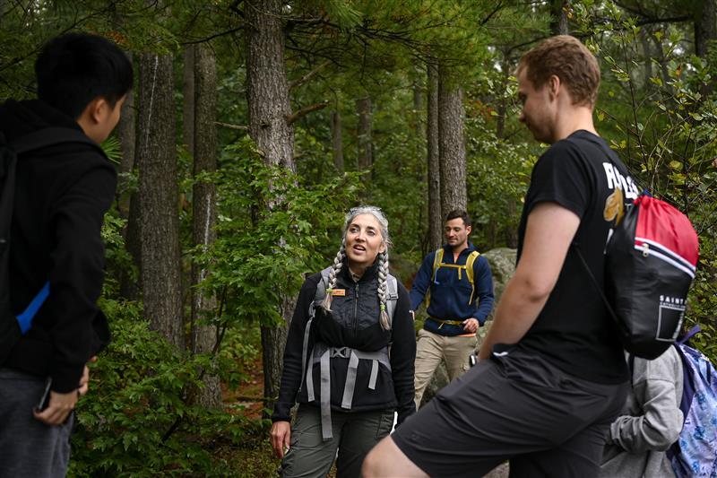Three people standing in the woods