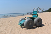 A beach wheelchair with large, inflatable tires on a sandy beach. 