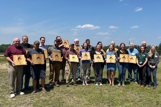 Recipients of the 2025 Invasive Species Action Awards stand with their plaques during the recognition ceremony.