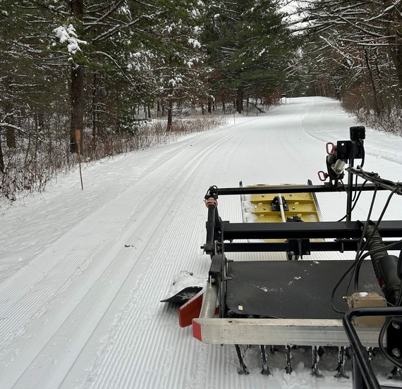 Cross country ski trail groomer on a snowy trail