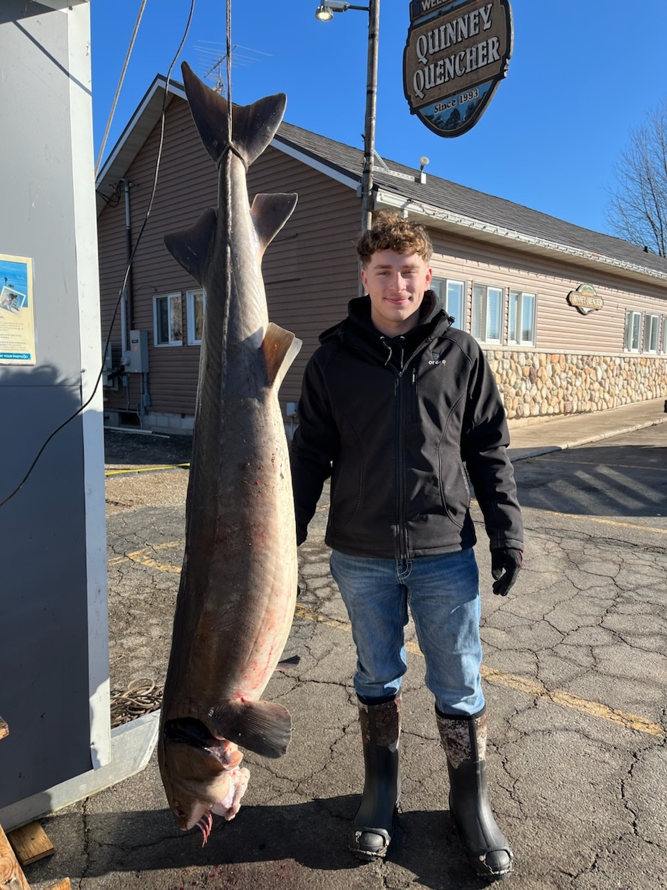 Jordan Schmitz standing next to the sturgeon he speared
