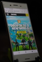 Photo of phone with Fortnite game displayed on screen