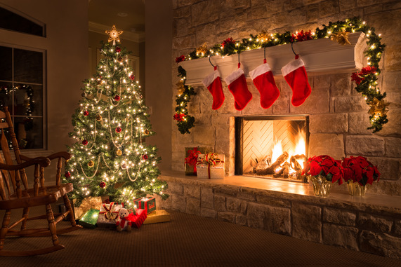 Christmas decorations around a fireplace with a fire burning