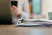 stack of papers on a desk with laptop