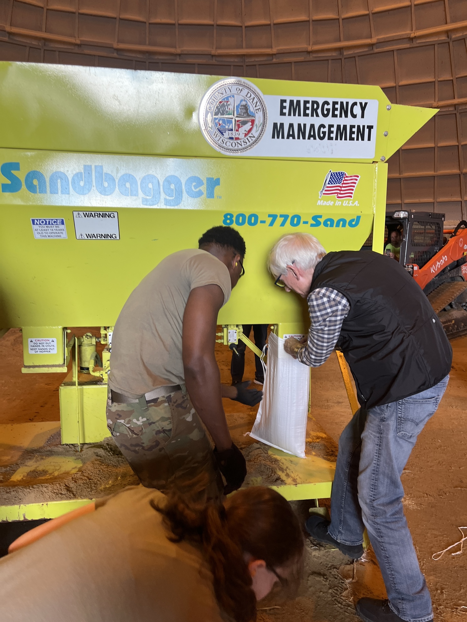 Governor Evers and a Wisconsin National Guard member pack sandbags. 
