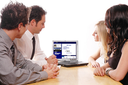 People gathered around a computer screen participating in a webinar