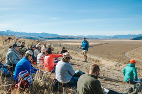 Teachers participating in an place-based workshop outdoors with Teton Range in background