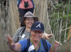 Two teachers hiking across a rope bridge in the Amazon Rainforest