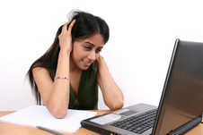 Female students looking perplexed while working on laptop