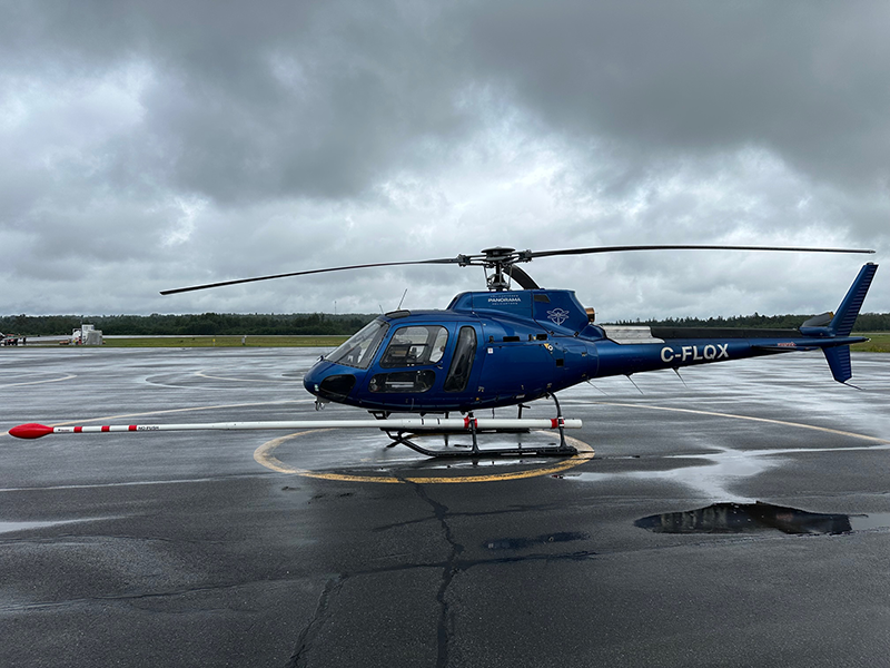 A helicopter equipped with a stinger-mounted magnetometer and gamma-ray spectrometer.