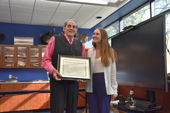 Volunteer of the Year Jim Rayls holding his certificate beside the WSM's Curator of Community Engagement Melisa McChesney