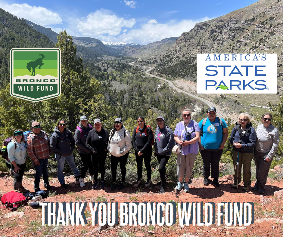 women hiking with scenic overlook. bronco wild fund and america's state parks logos