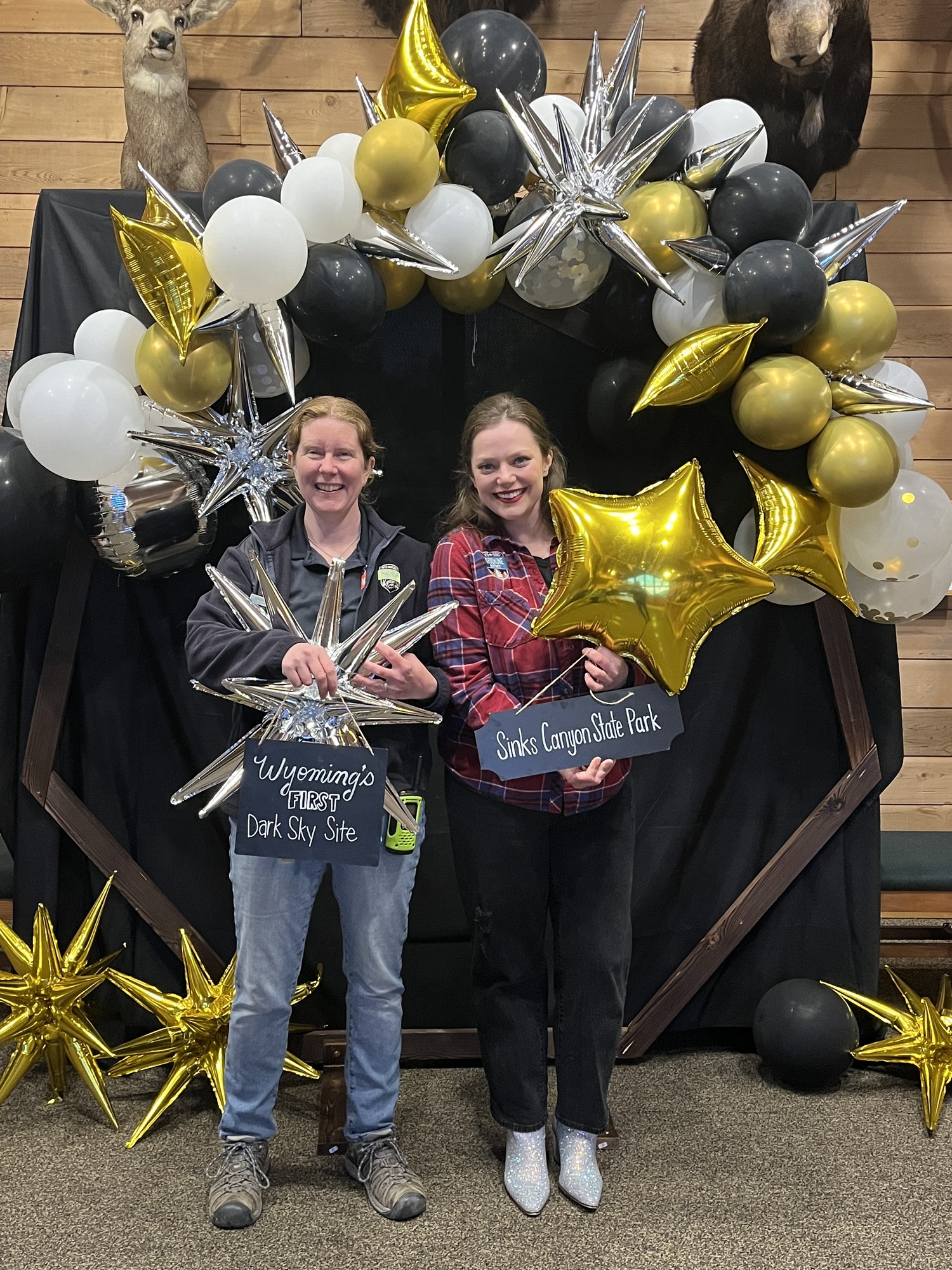metallic balloon arch with two park employee women posing with balloons