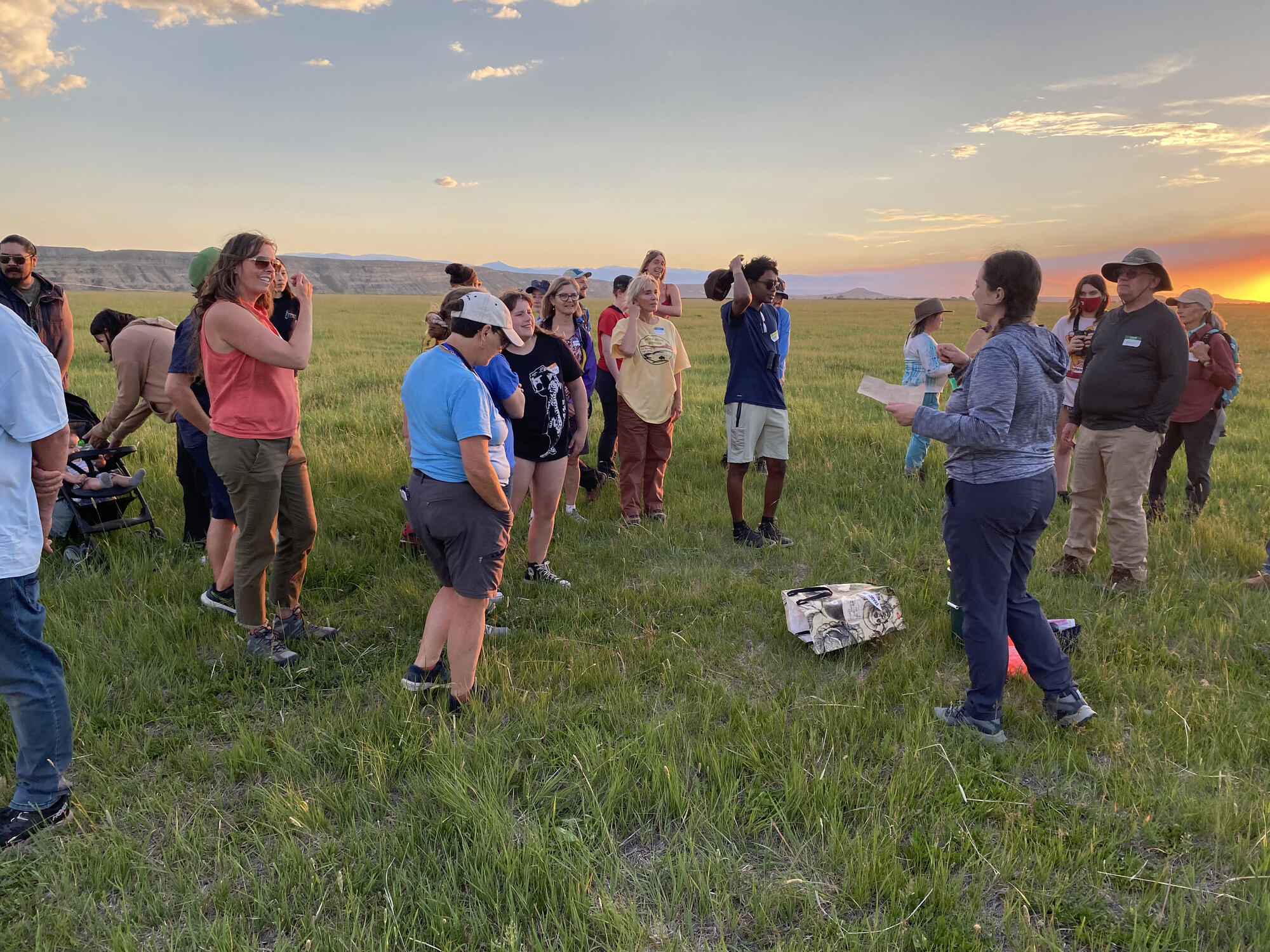 sunset with folks standing in a field