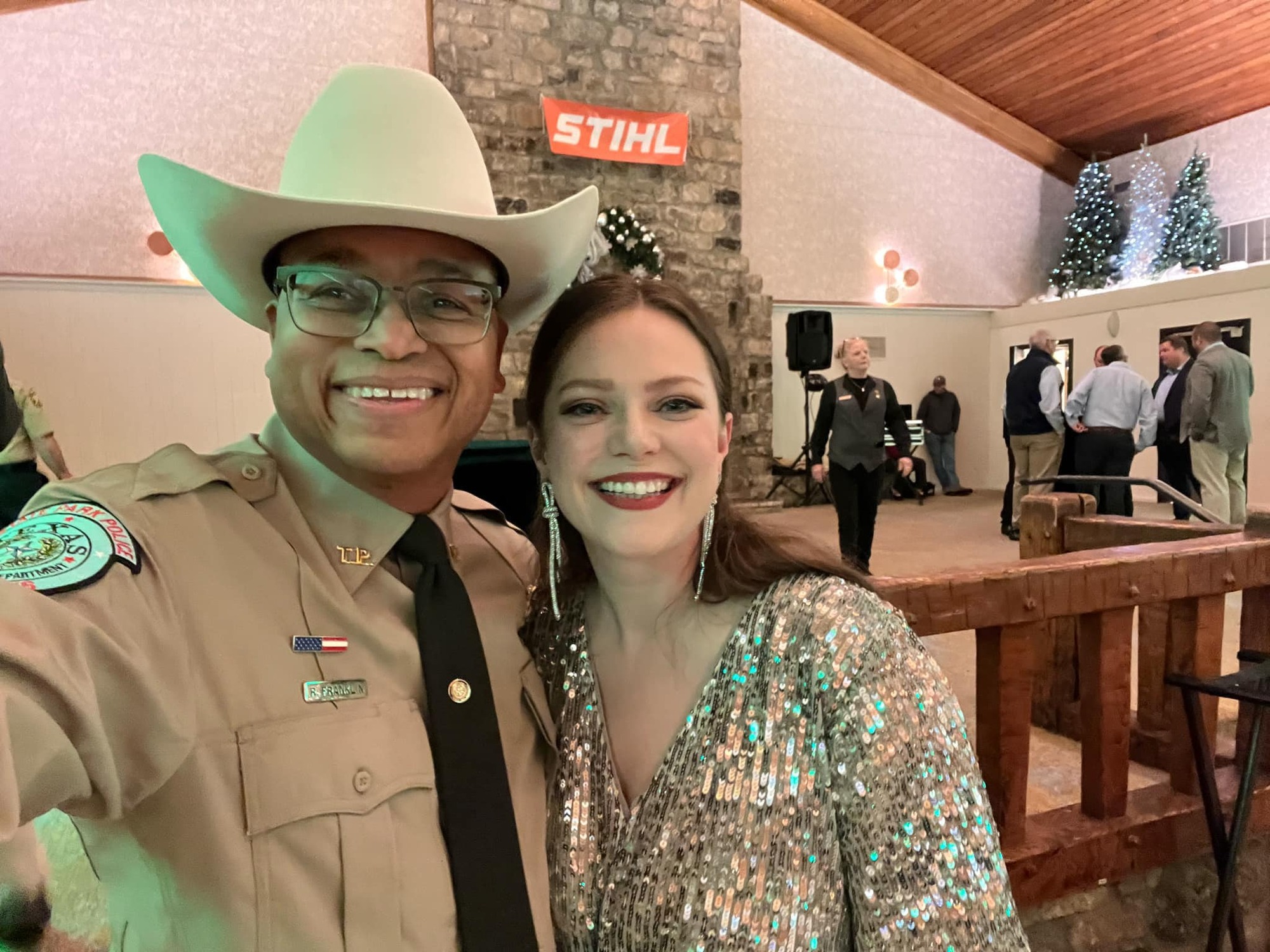 Cowboy hat man in ranger uniform and woman in sparkly dress