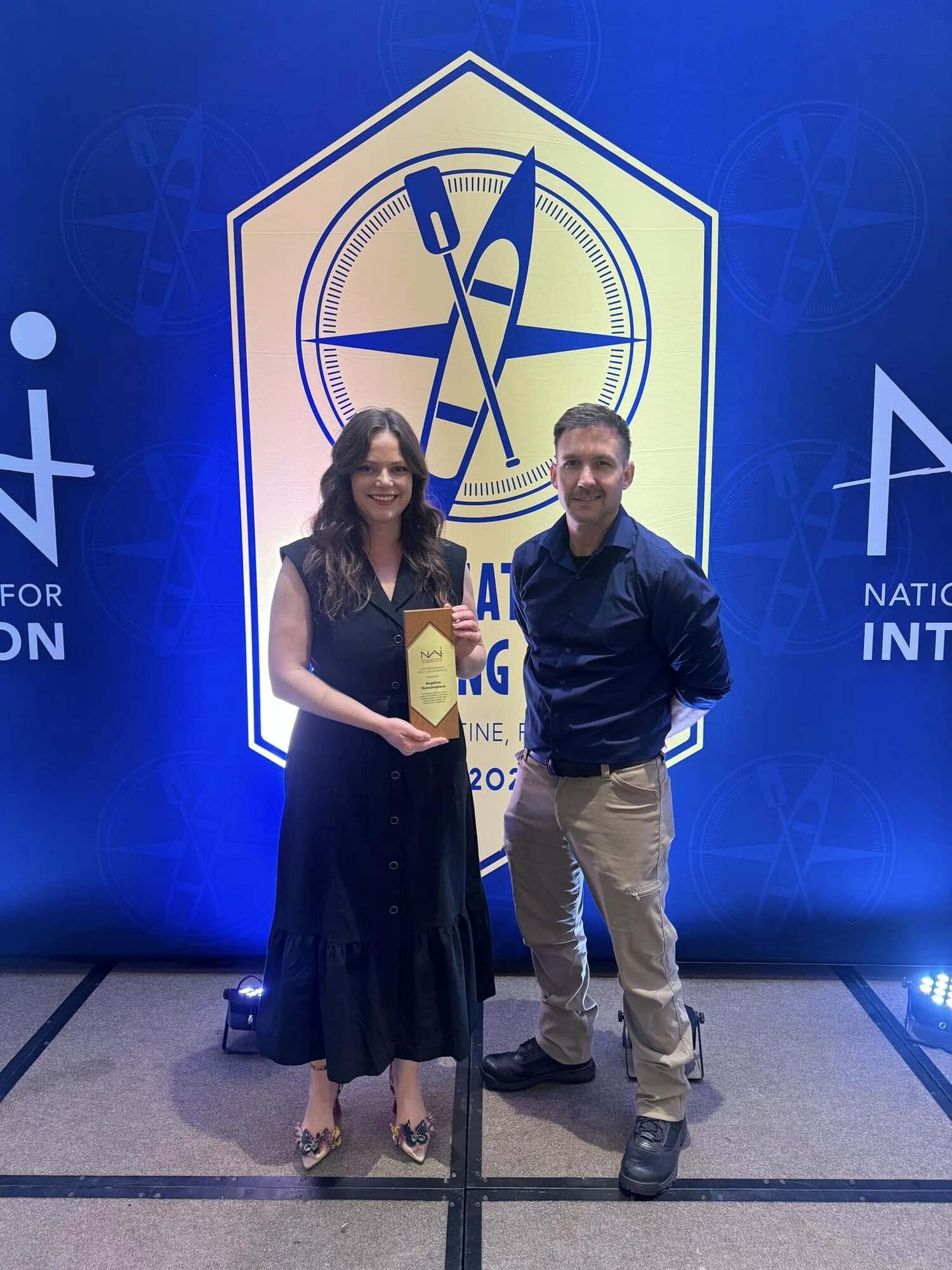 man and woman on stage with award