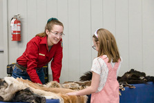 Game and Fish employee speaks to child at Mule Deer Days table