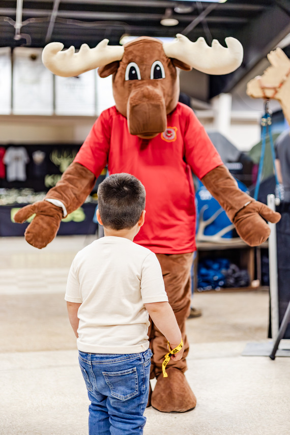 Mardy the moose greeting a kid at Mule Deer Days